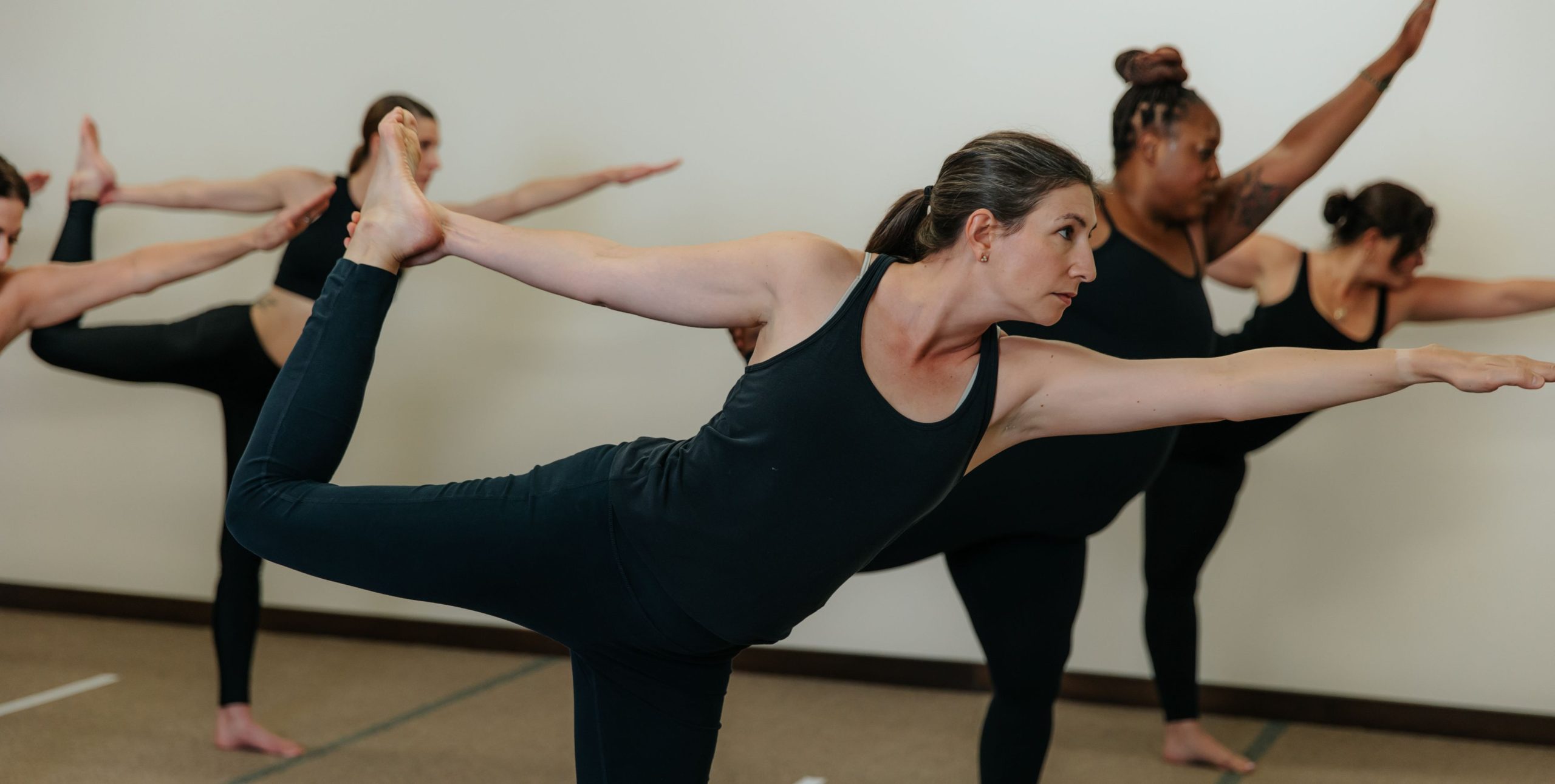 Yoga Is Medicine students practicing Standing Bow together in the hot room